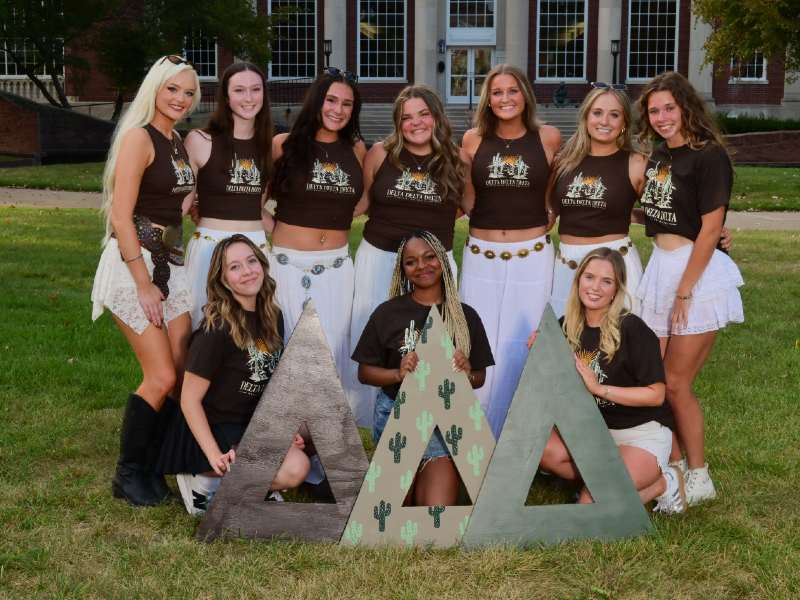 Women surrounding Tri Delta Letters