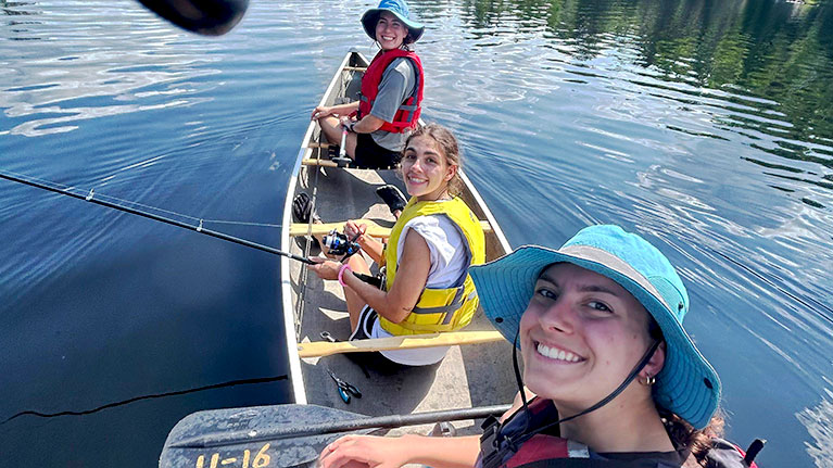 students on boat on lake