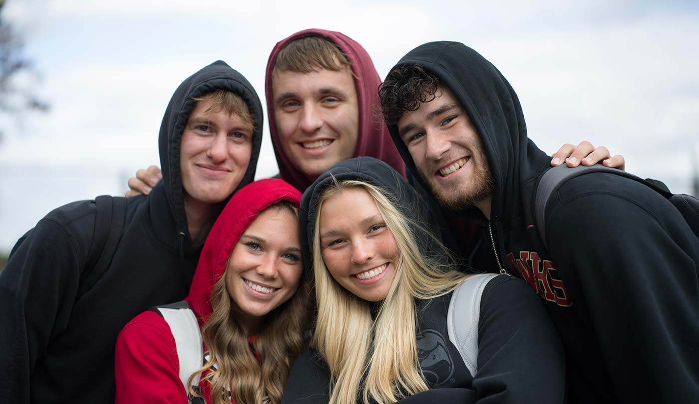 Coe students smiling in hoodies