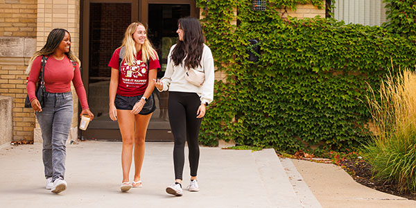Three female Coe students talking outside of Stuart Hall