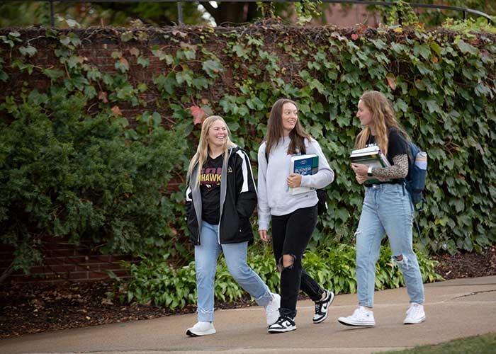 Three-female-students-walking-on-campus-laughing.jpg