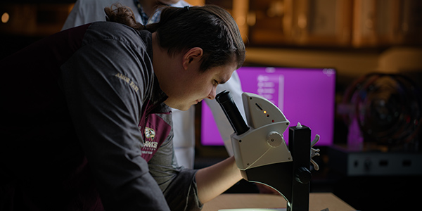 Student looking into microscope