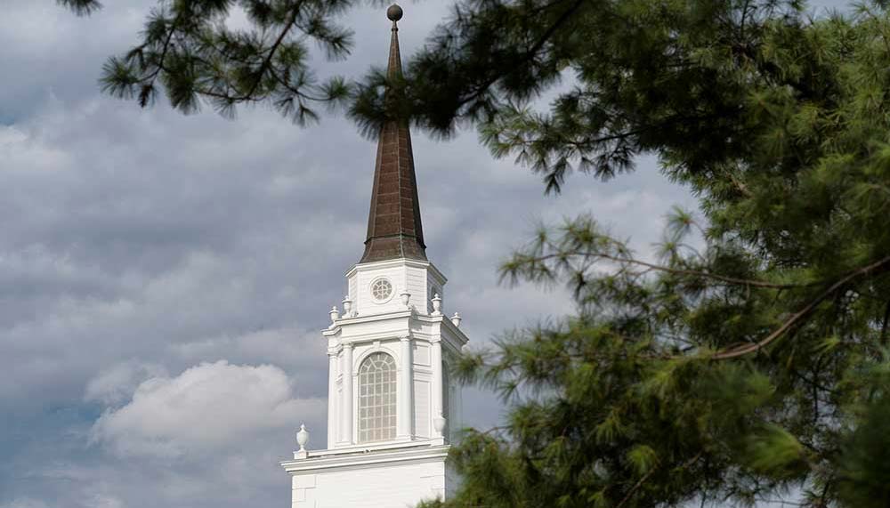 Sinclair steeple framed by trees