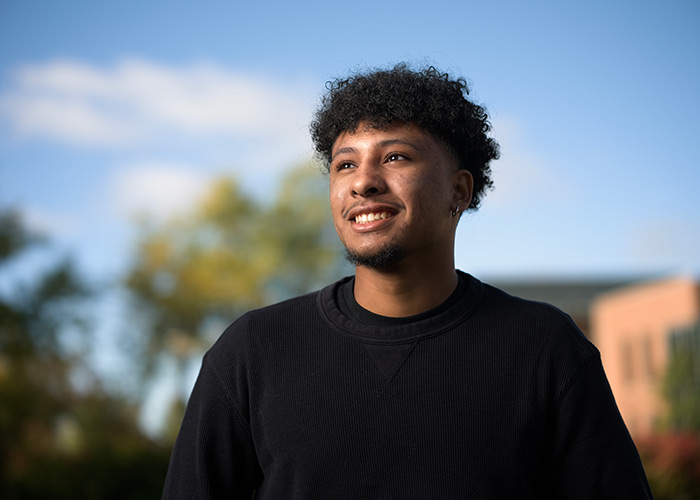 Male Coe student smiling into the distance