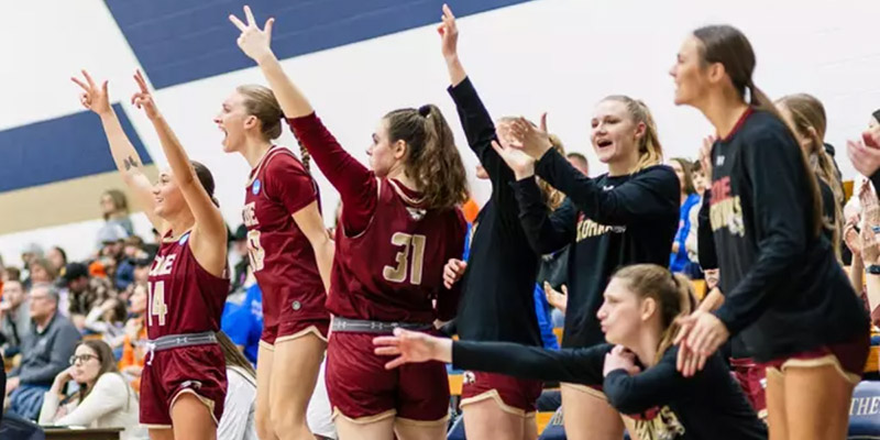 Kohawk women's basketball players jump off the bench in celebration