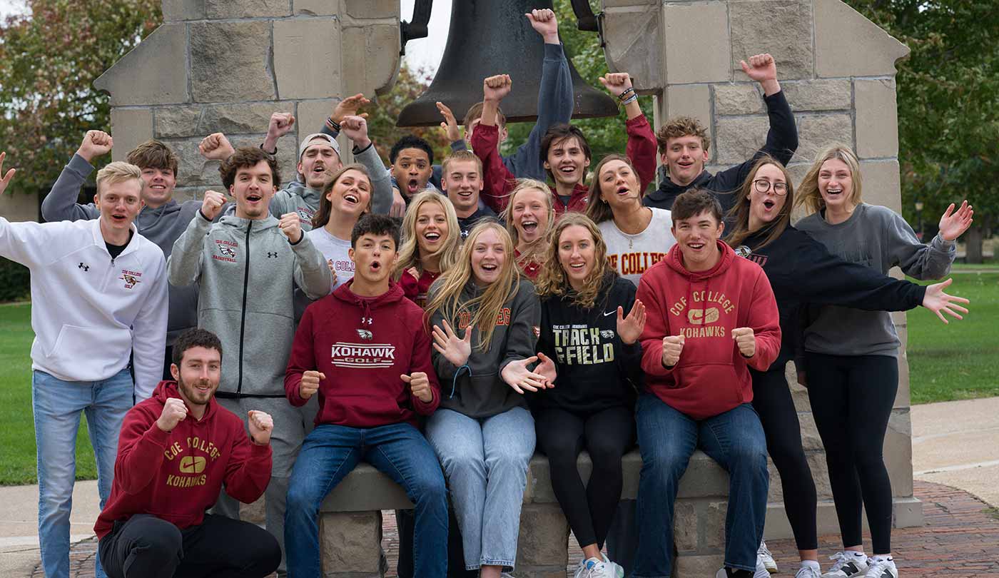 Crowd of Coe students cheering in front of the Victory Bell