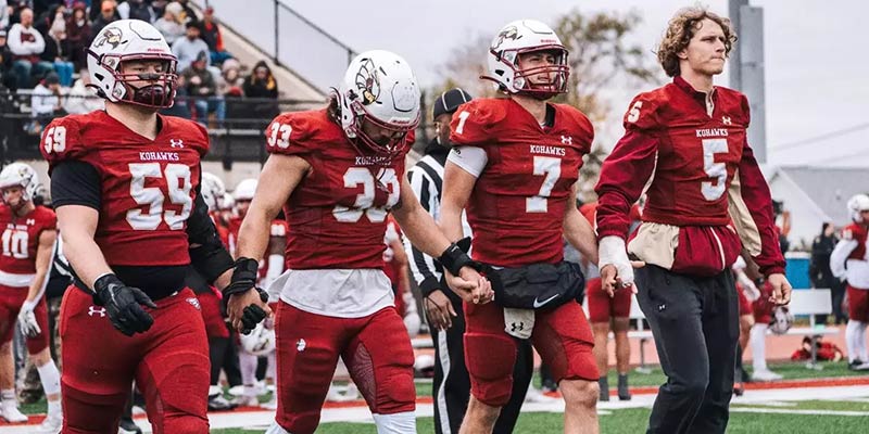 Coe College football players holding hands