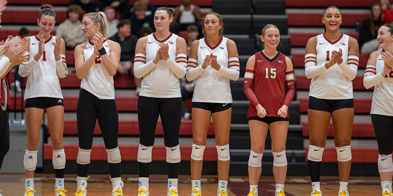 Coe College volleyball players clapping