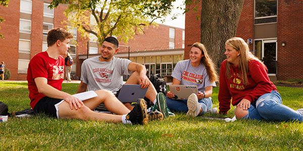 Four Coe students studying on the quad